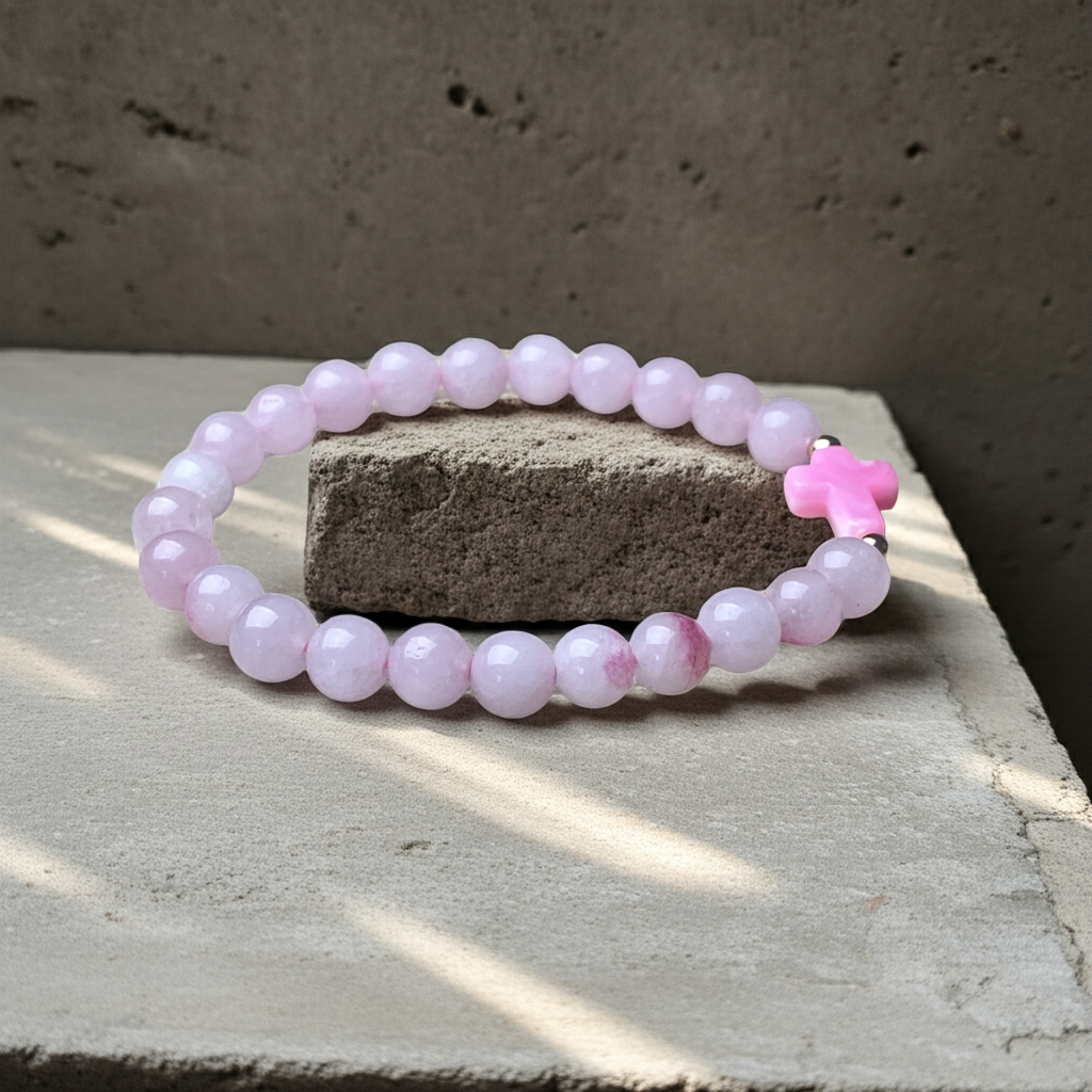 Pink beaded bracelet on a concrete surface with a textured background