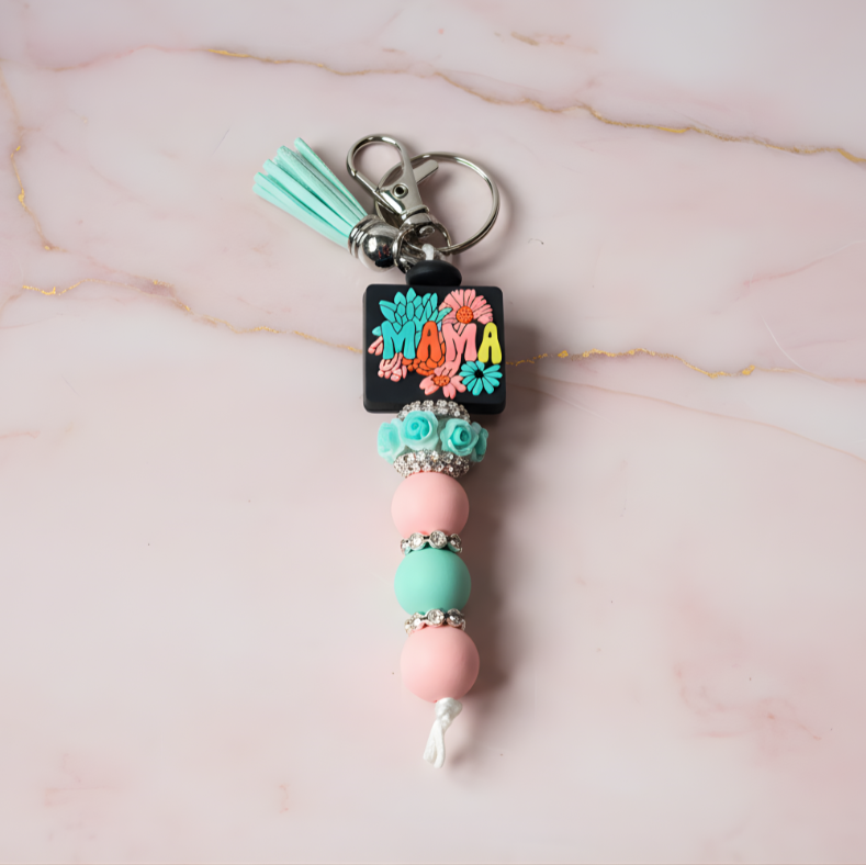 Colorful keychain with beads and decorative elements on a marble background