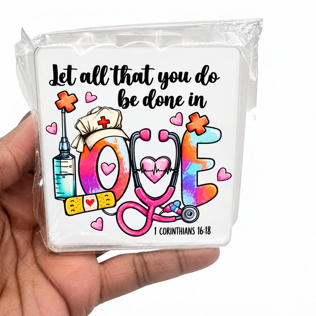 A hand holding a clear plastic case featuring a colorful medical-themed design with the phrase 'Let all that you do be done in love' and illustrations of a stethoscope, syringe, nurse hat, and hearts.
