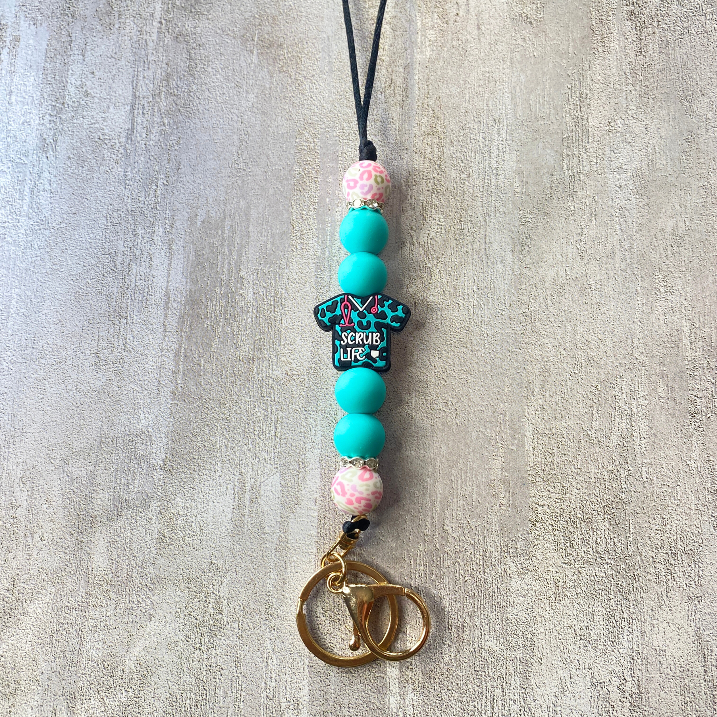 Beaded keychain with decorative elements on a textured surface