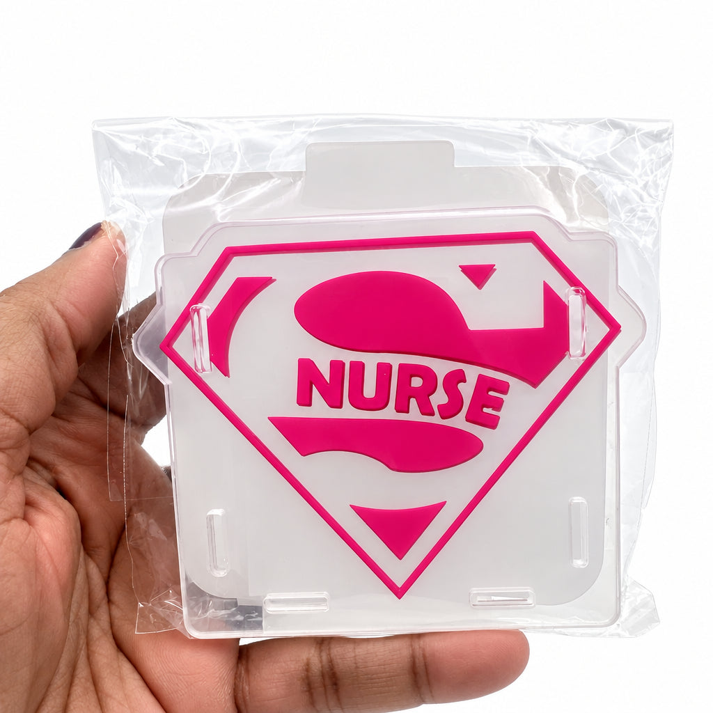 A hand holding a clear plastic-wrapped acrylic sign featuring a pink superhero-style shield with the word 'NURSE' in the center, against a plain light background.